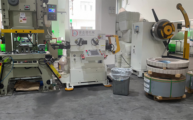 Transfer press line overview with decoiler straightener feeder and stamping robots Трансферна пресова линия с размотаващо устройство, изправящо устройство, подаващо устройство, щанцови роботи и множество преси