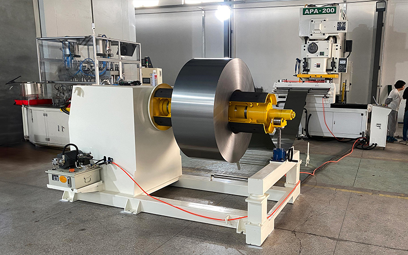 NC servo feeder accurately advancing strip into press NC servo feeder paired with metal decoiler