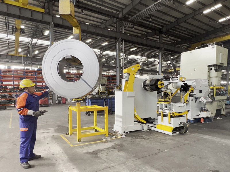 Loading the uncoiler with coil using crane and positioning arms Step 1: Loading coil onto 3-in-1 uncoiler with press arm and positioning guide